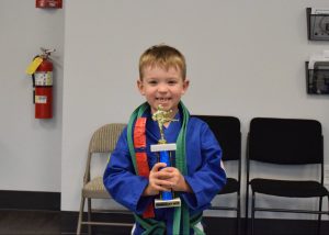 child holding karate trophy 