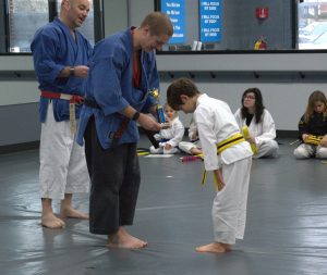 child bowing to Sensei while getting trophy