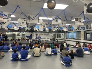 Students and parents sitting on the mat and learning from Renshi Matt