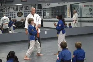 Two kids helping demonstrate karate for O'Sensei